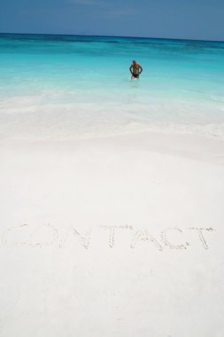 contact drawn on the sand of a beach clipart