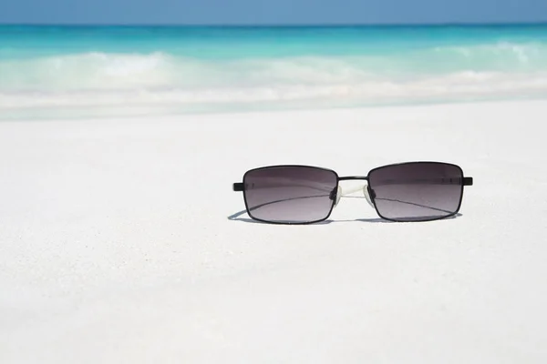Gafas de sol en la playa — Foto de Stock