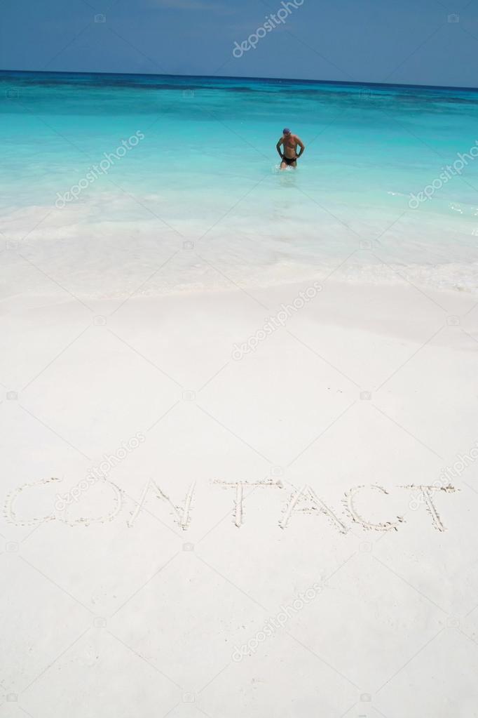 contact drawn on the sand of a beach