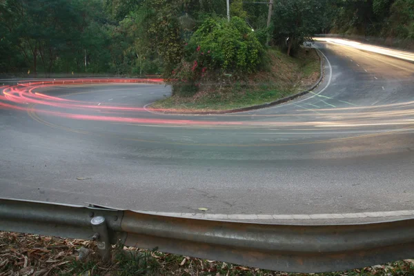 Strada curva tagliente con linea di luce auto — Foto Stock