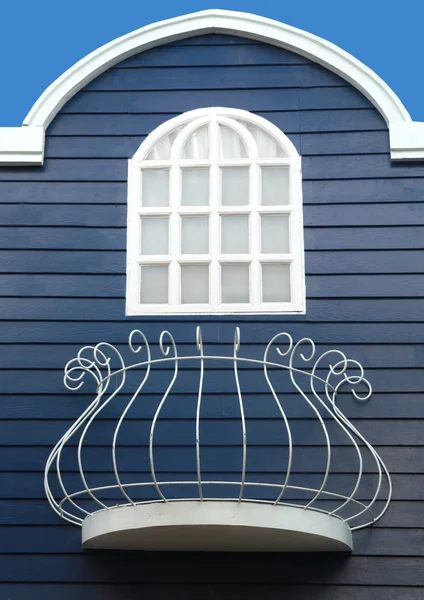 Fenêtre blanche avec terrasse sur mur en bois bleu — Photo