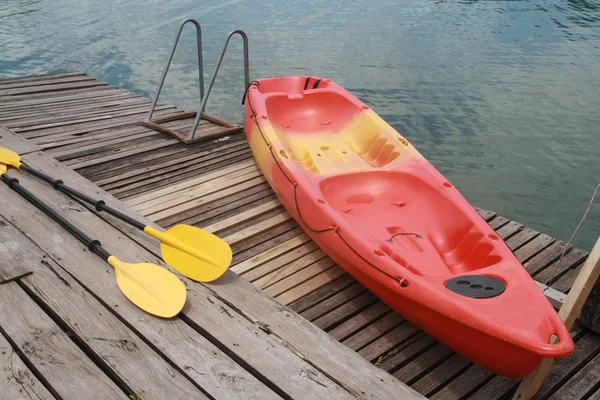 Red kayak on wood floor — Stock Photo, Image