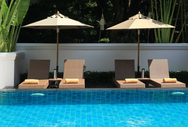 Deck umbrella and swimming pool — Stock Photo, Image