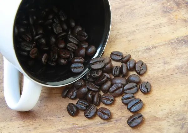 Grãos de café cair da xícara — Fotografia de Stock