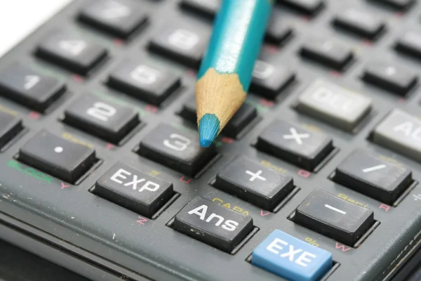 Blue wooden pencil on calculator — Stock Photo, Image