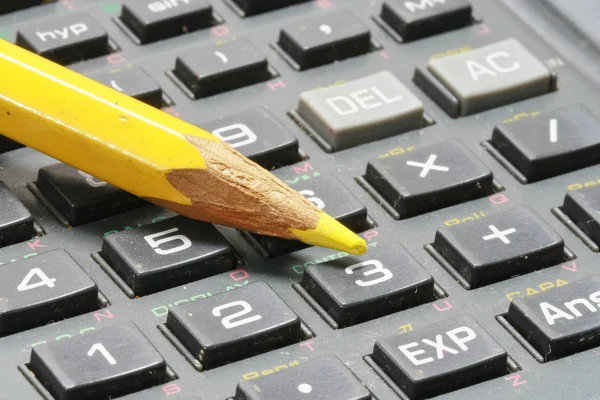 Lápis amarelo na calculadora preta — Fotografia de Stock