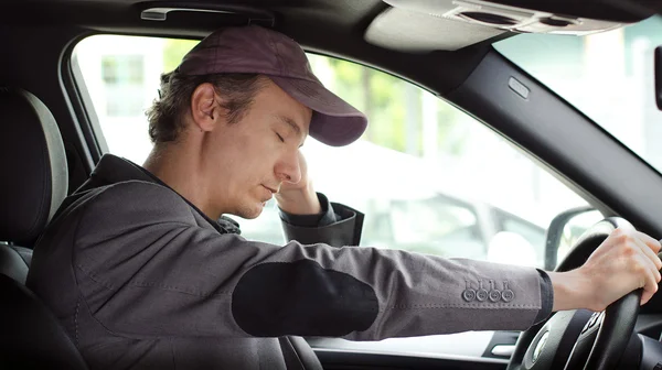 Verveeld man achter het stuur van zijn auto slapen — Stockfoto