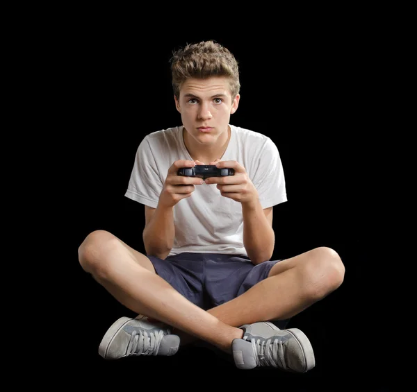 Cute tiener zittend op de vloer spelen van videogames — Stockfoto