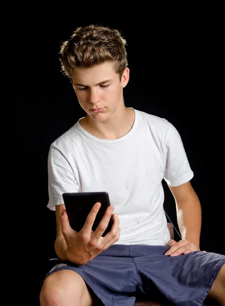 Menino sentado com leitor de ebook ou tablet em sua mão — Fotografia de Stock