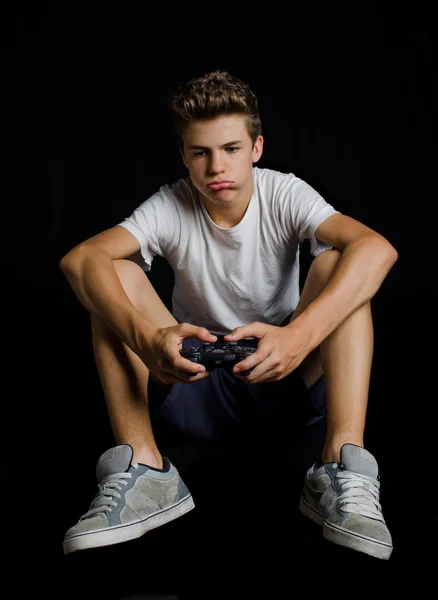 Скучный или разочарованный мальчик, играющий в видеоигры — стоковое фото