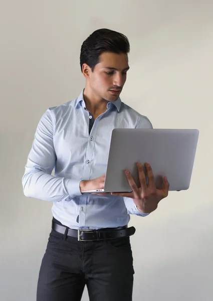 Hombre joven de pie y trabajando en el ordenador portátil — Foto de Stock