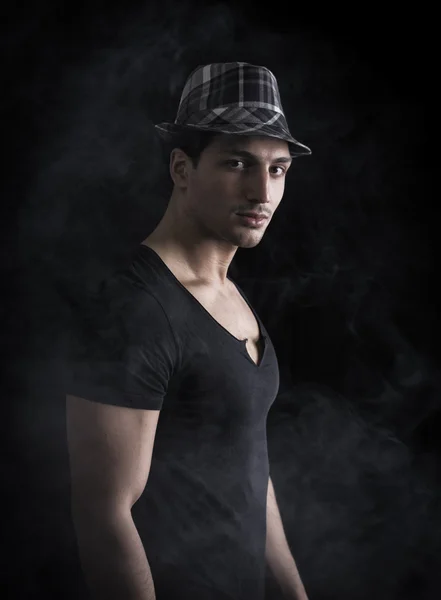 Young man with black and white checkered hat. Smoke around him — Stock Photo, Image