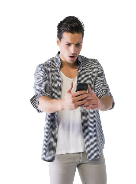 Giovane uomo guardando il cellulare con espressione arrabbiata — Foto Stock