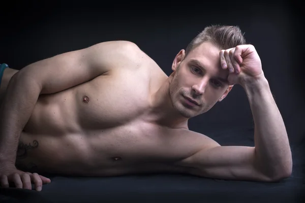 Handsome young man naked on floor. — Stock Photo, Image