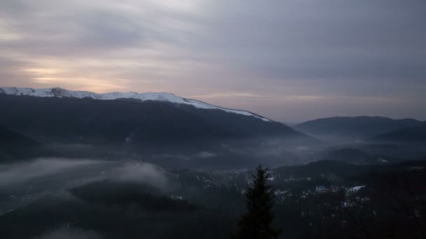 Sonnenaufgang in der Nähe der Stadt zwischen Bergen mit bewölktem Himmel und Nebel — Stockvideo