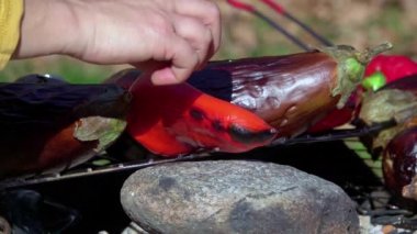 Taze kesilmiş karışık sebzeler ve sosisler açık havada mangal kömürü ızgarasında kızartılıyor. Yavaş çekim
