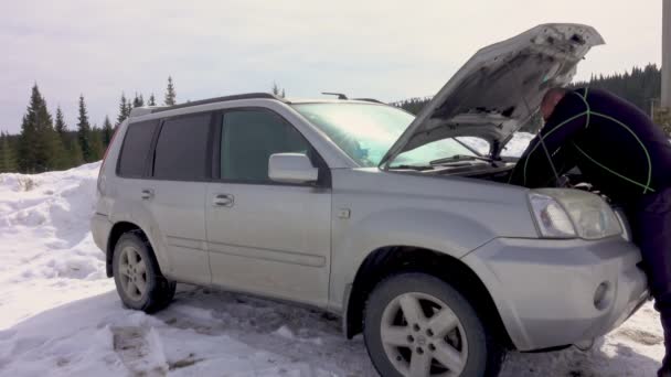 Człowiek Naprawia Lub Naprawia Zepsuty Samochód Górach Zimowych Próbuję Zidentyfikować — Wideo stockowe