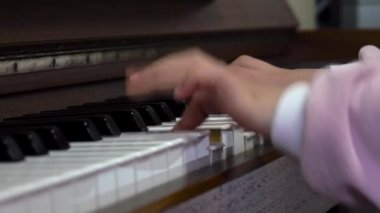 Child playing piano. Close up