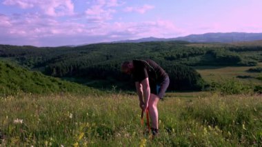 Man training outdoors. Sunset, over green hill