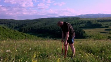 Man training outdoors. Sunset, over green hill