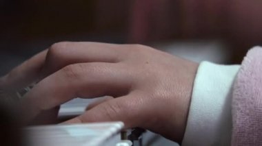 Child playing piano. Close up