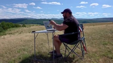 Man with laptop sitting and networking in the country
