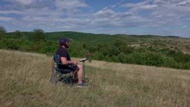 Artist with practice pads and headsets in summer meadow