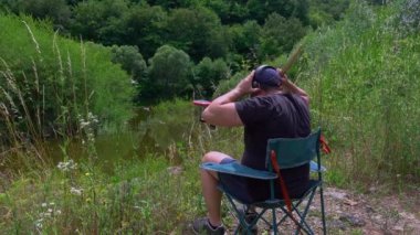 Artist with practice pads and headsets near mountain lake