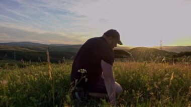 Man with laptop sitting and networking in the country
