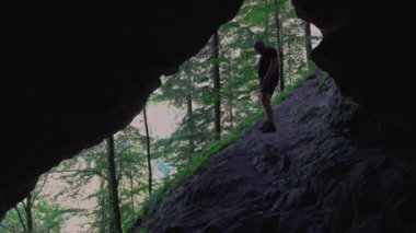 Hiker relax and read books outdoor, in a cool cave