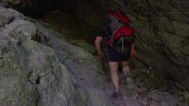 Hiker walking in a cave. People in nature concept.
