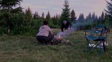 Hiker starting campfire at dawn