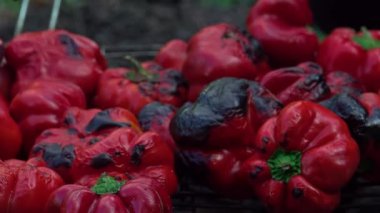 Kadın dışarıda ızgarada dolmalık biber hazırlıyor. Kış için sebzeler.
