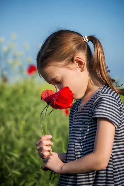一个可爱的女孩拿着一束红罂粟的画像 — 图库照片