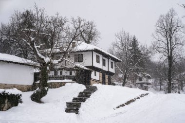 Bulgaristan 'ın yeniden canlanan mimari kompleksi Bozhenci' deki eski güzel evlerin üzerine yağan karla birlikte, sakin kış sabahının şaşırtıcı manzarası