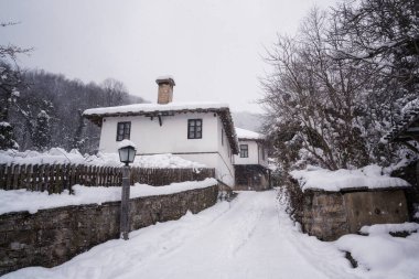 Bulgaristan 'ın yeniden canlanan mimari kompleksi Bozhenci' deki eski güzel evlerin üzerine yağan karla birlikte, sakin kış sabahının şaşırtıcı manzarası