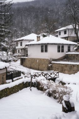 Bulgaristan 'ın yeniden canlanan mimari kompleksi Bozhenci' deki eski güzel evlerin üzerine yağan karla birlikte, sakin kış sabahının şaşırtıcı manzarası.