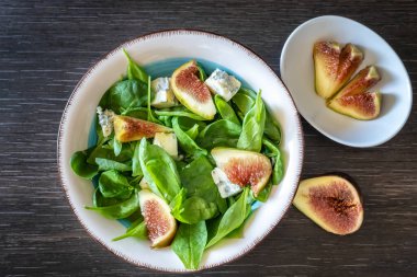 Bebek ıspanaklı taze salata, mavi peynir ve incirli salata kasesi, yakın plan.