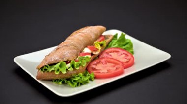 Lezzetli vejetaryen caprese sandviçi videosunu koyu arkaplanda bir tabakta kapat