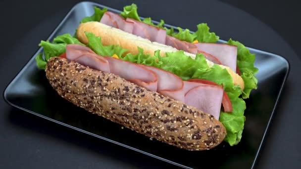 Video Van Lekkere Sandwiches Met Ham Gesmolten Kaas Groenten Zwarte — Stockvideo