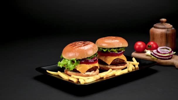 Pár Ízletes Házi Marhahúsos Hamburger Sült Krumplival Fekete Tányéron Közeli — Stock videók