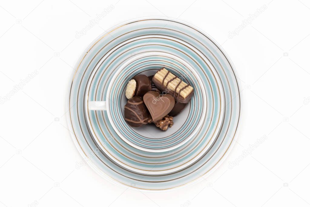 Chocolate candies in a vintage porcelain cup for valentines day on white background