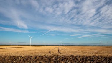 Yaz tarlalarında rüzgar türbinleri ile hızlandırılmış video. Temiz ve yenilenebilir rüzgar enerjisi çiftliği hareket halinde. Yeşil enerji, sürdürülebilir alternatif elektrik, kirlilik ortamı yok