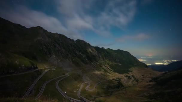 素晴らしい時間経過ビデオとともに澄んだ夜空に満月上の有名なTransfogarasan山岳道路でルーマニア — ストック動画