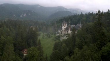 Romanya 'nın Sinaia kenti yakınlarında, güzel Peles Kalesi ve etrafındaki sisli ormanın üzerinde insansız hava aracı uçuşuyla inanılmaz bir video.