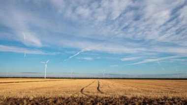 Yaz tarlalarında rüzgar türbinleri ile hızlandırılmış video. Temiz ve yenilenebilir rüzgar enerjisi çiftliği hareket halinde. Yeşil enerji, sürdürülebilir alternatif elektrik, kirlilik ortamı yok