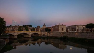 Roma 'nın, Vatikan' ın Aziz Peter Bazilikası ve İtalya 'nın Tiber Nehri üzerindeki St. Angelo Köprüsü' nün üzerinden gece gündüz geçen görüntüleri. Hareket eden bulutlarla gün doğumu görünümü.
