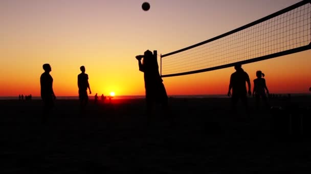Силуэт Друзья играют в волейбол на пляже — стоковое видео