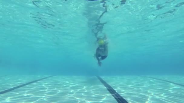 Медленный человек плывет под водой в бассейне — стоковое видео