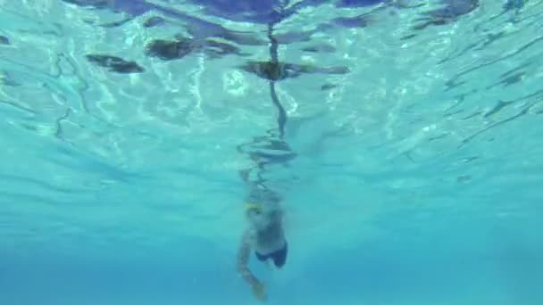 Медленный человек плывет под водой в бассейне — стоковое видео